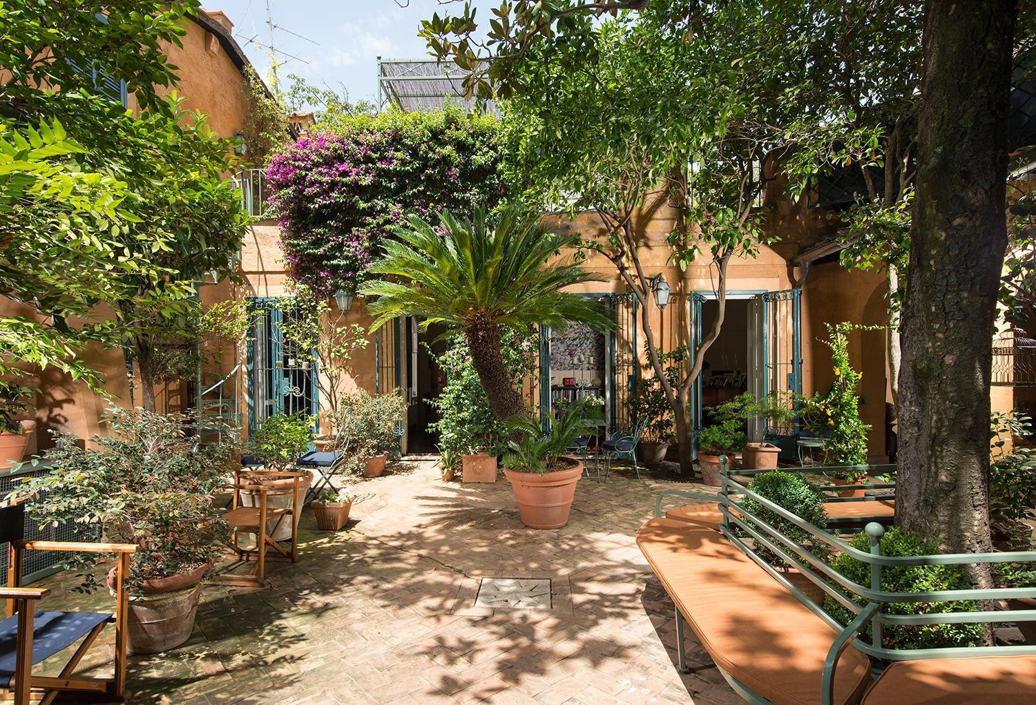 giardino mediterraneo con vasi e piastrelle in terracotta