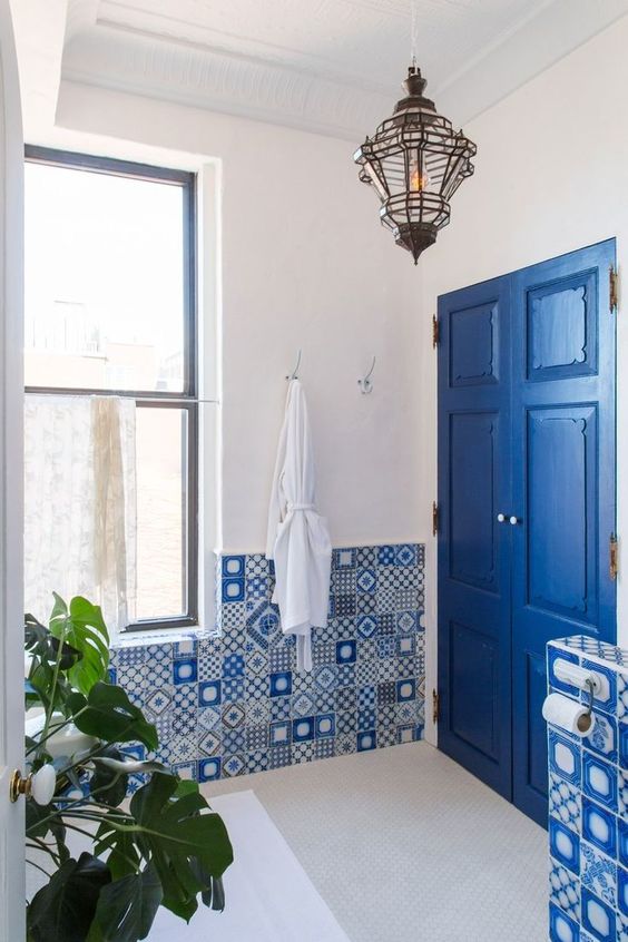 Bagno con piastrelle azzurre in stile greco decorate